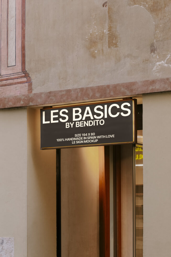 Outdoor shop sign mockup on textured wall displaying Les Basics. Ideal for graphic designers and branding presentations. Signage design asset.