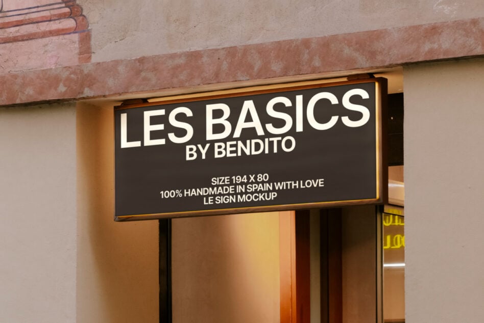 Dark exterior storefront sign with gold trim mounted above entrance with warm lighting