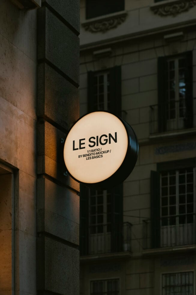 Round illuminated sign mockup on urban wall for designers. Ideal for showcasing branding, logos, and graphic design projects in a street setting.
