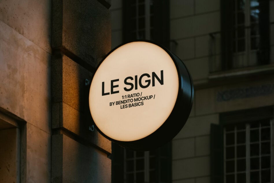 Illuminated circular storefront sign with white background displaying black text