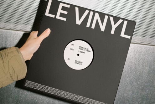 Hand holding a vinyl record cover mockup with minimal design and monochrome palette. Perfect for designers seeking high-quality presentation templates.