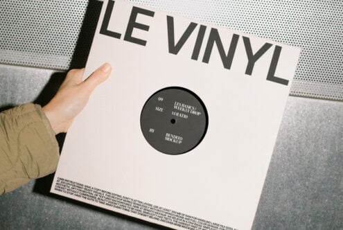 Vinyl record mockup held by hand with a minimalist cover design suitable for showcasing album artwork. Perfect for designers' projects and templates.