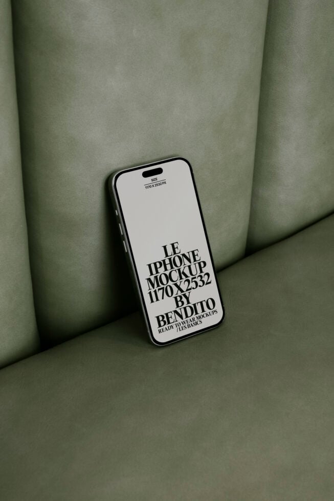 iPhone mockup on green leather surface showcasing editable screen design. Perfect for designers seeking high-quality device mockups digital assets templates.