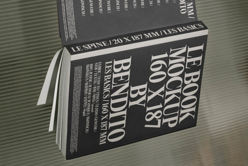Black hardcover book mockup at angle showing open pages with thick binding