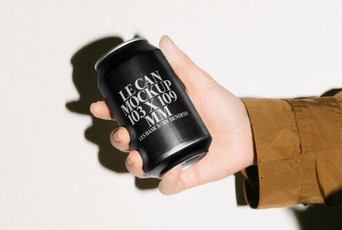 Hand holding sleek black can mockup with stylish typography design ideal for graphic designers creating branding presentations packaging templates