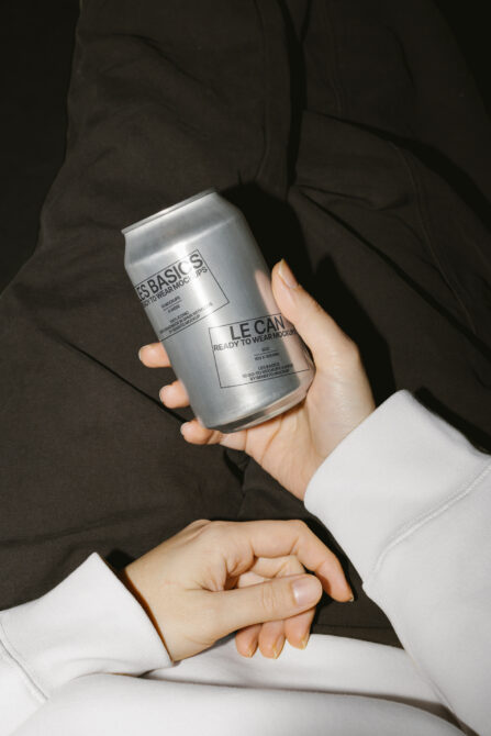 Silver aluminum beverage can in hands with white shirt cuff showing