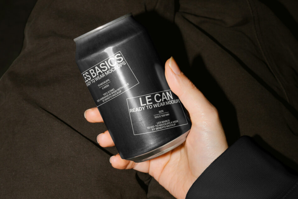 Dark metallic can mockup held by person in formal black clothing indoors