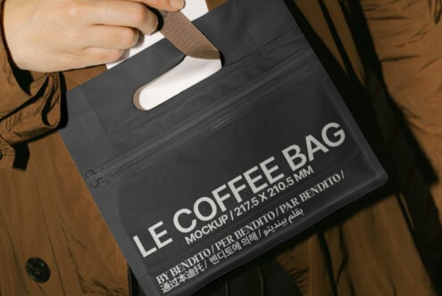 Hand holding a black coffee bag mockup with text detailing dimensions 217.5 x 210.5 mm ideal for designers looking for packaging graphics SEO keywords
