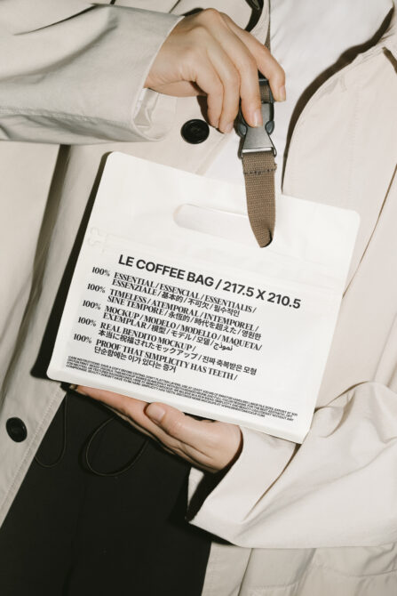Close-up of a hand holding a white minimalist coffee bag with text, showcasing packaging design. Ideal for mockup, branding, and graphic design projects.