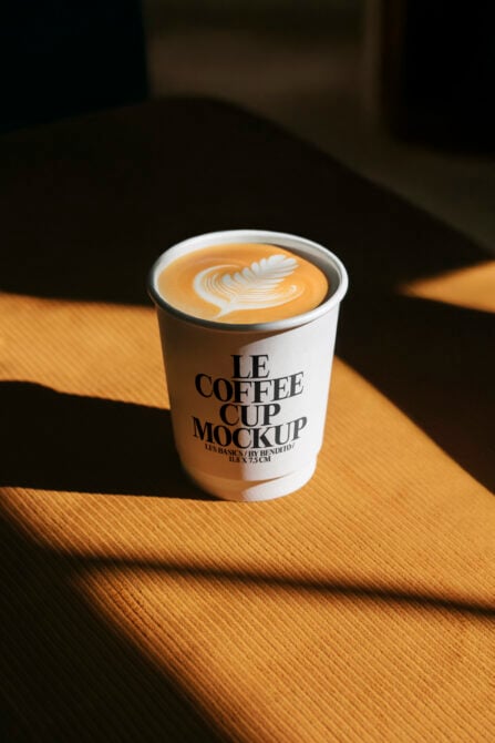 Coffee cup mockup featuring latte art, modern design. Ideal for showcasing branding projects. Keywords: mockup, coffee, latte, design, branding.