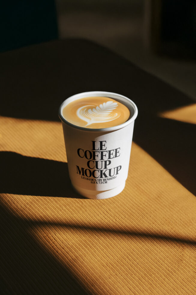 Coffee cup mockup featuring latte art, modern design. Ideal for showcasing branding projects. Keywords: mockup, coffee, latte, design, branding.