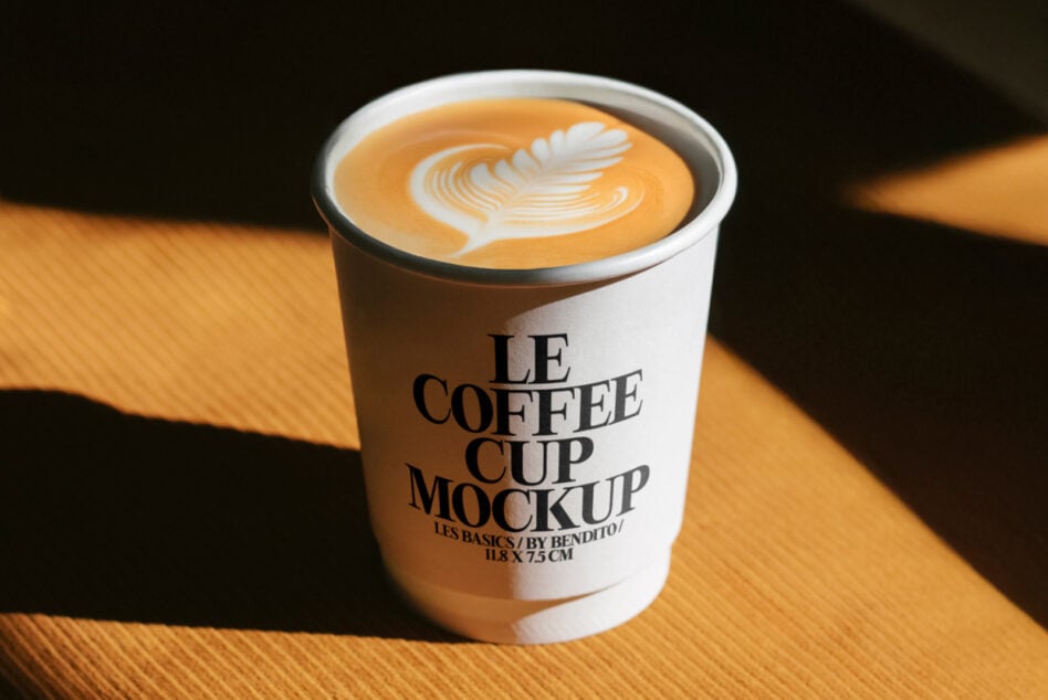 Coffee cup mockup featuring latte art for designers. Ideal for showcasing branding designs in a realistic setting. Mockup template asset.