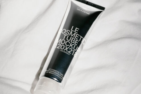 Cosmetic tube mockup placed on white fabric background ideal for showcasing branding designs. Perfect for designers seeking high-quality mockup templates.