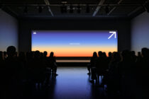 Audience viewing large gradient screen in dark room ideal for mockup designs or presentation template showcasing ColorTime Lab branding sleek visuals