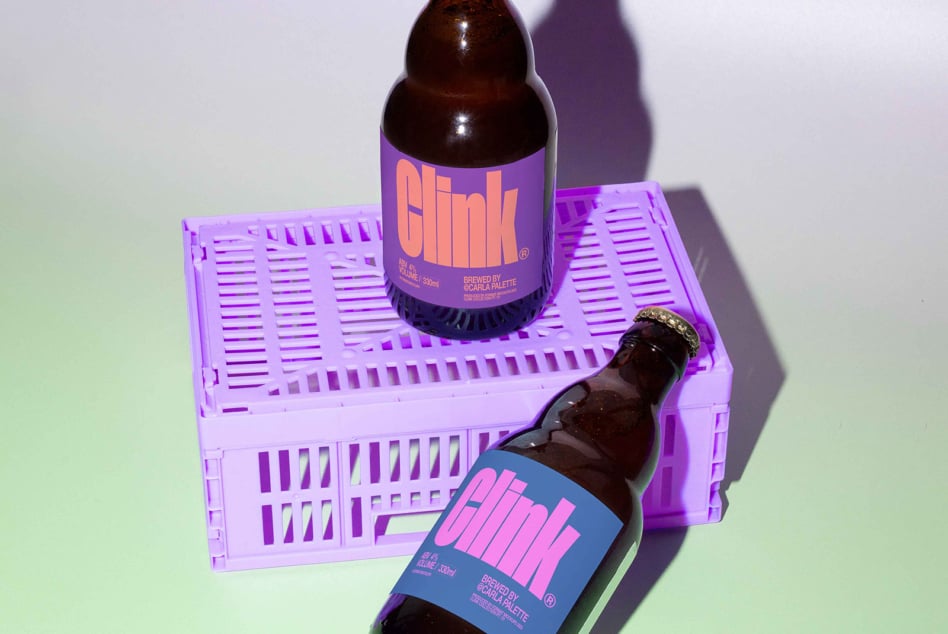 Mockup of two beer bottles with bold typography and colorful labels resting on a purple crate. Perfect for branding projects, graphic design, and packaging inspiration.