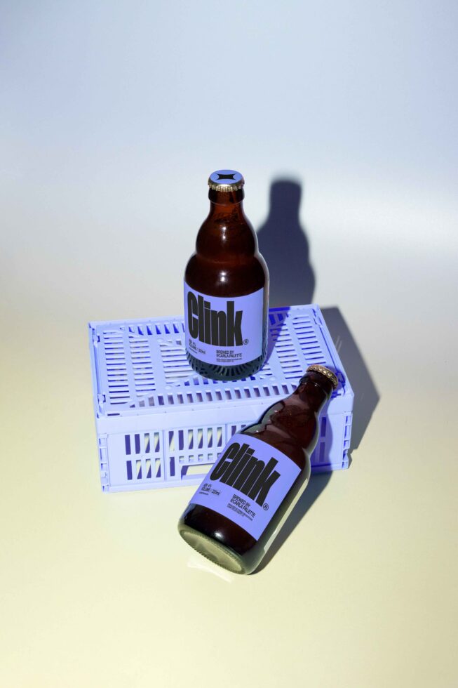 Craft beer bottle mockup featuring minimalist label design brown bottles placed on a blue crate ideal for branding presentations and product showcases