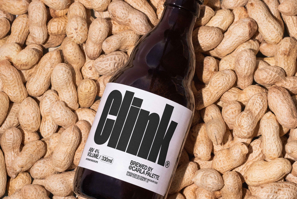 Beer bottle with black vertical stripe logo on white label surrounded by peanuts