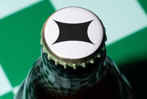 Bottle cap with abstract logo design mockup on green checkered background perfect for branding and packaging templates for designers.