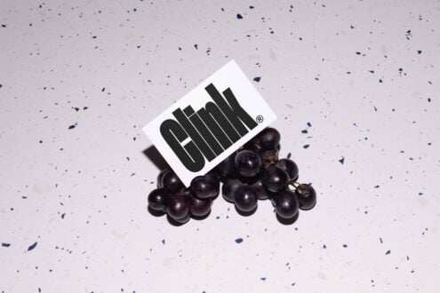 Grapes with a card showcasing bold modern font Clink. Perfect for graphic design mockups and typography projects. Ideal for designers seeking unique assets.