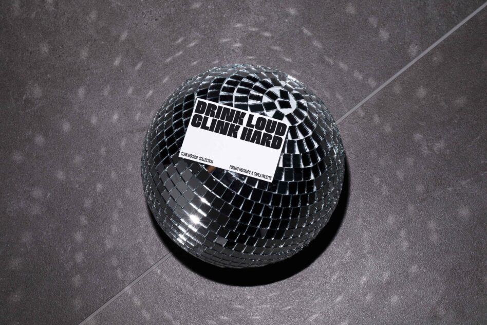 Reflective disco ball displaying white label on gray concrete surface