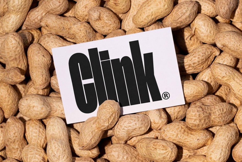 White business card with black Olimli logo resting on scattered peanuts