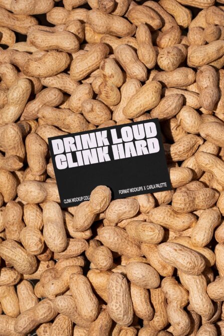 Black label on pile of roasted peanuts overhead flat lay composition