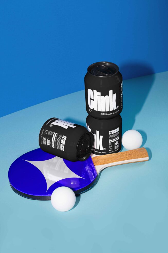 Mockup of black soda cans with bold text on blue background, paired with ping pong paddle and balls. Ideal for designers seeking modern design assets.