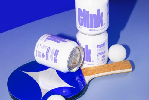 Modern beverage can mockups featuring minimalist design with bold typography. Includes ping pong paddle and ball. Perfect for designers seeking packaging inspiration.