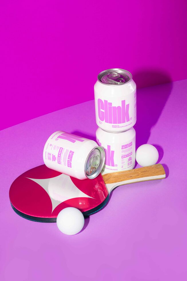 Pink can mockup with bold typography, table tennis paddle and balls on pink background. Perfect for designers seeking creative beverage packaging ideas.