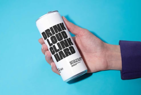 Hand holding a sleek white can with bold typography on a bright blue background packaging mockup design template for branding and presentation use