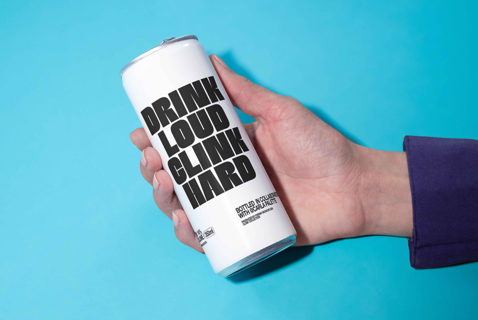Hand holding white beverage can with black text on turquoise background