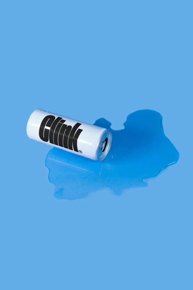 White beverage can with black horizontal lines on blue background puddle