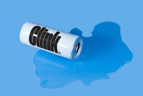 Mockup featuring a tipped white beverage can with bold typography on a blue background and liquid spill perfect for branding and product design presentations.