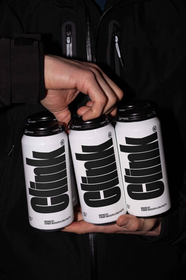 Three aluminum cans labeled clink held by a hand in a dark jacket. Ideal for mockup designs, product branding, packaging templates, and graphics.