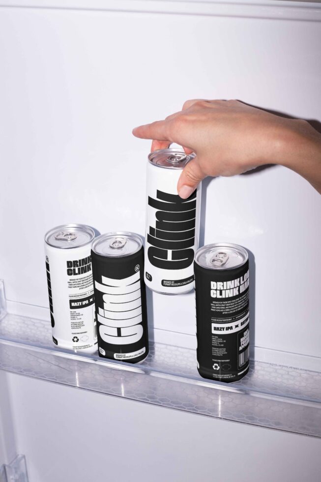 Hand reaching for a minimalist black and white soda can mockup inside a refrigerator. Ideal for product presentation mockup design branding templates.