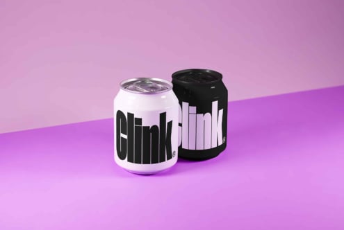 Mockup image showcasing two beverage cans with bold typography design on a vibrant purple background perfect for product branding and packaging design.