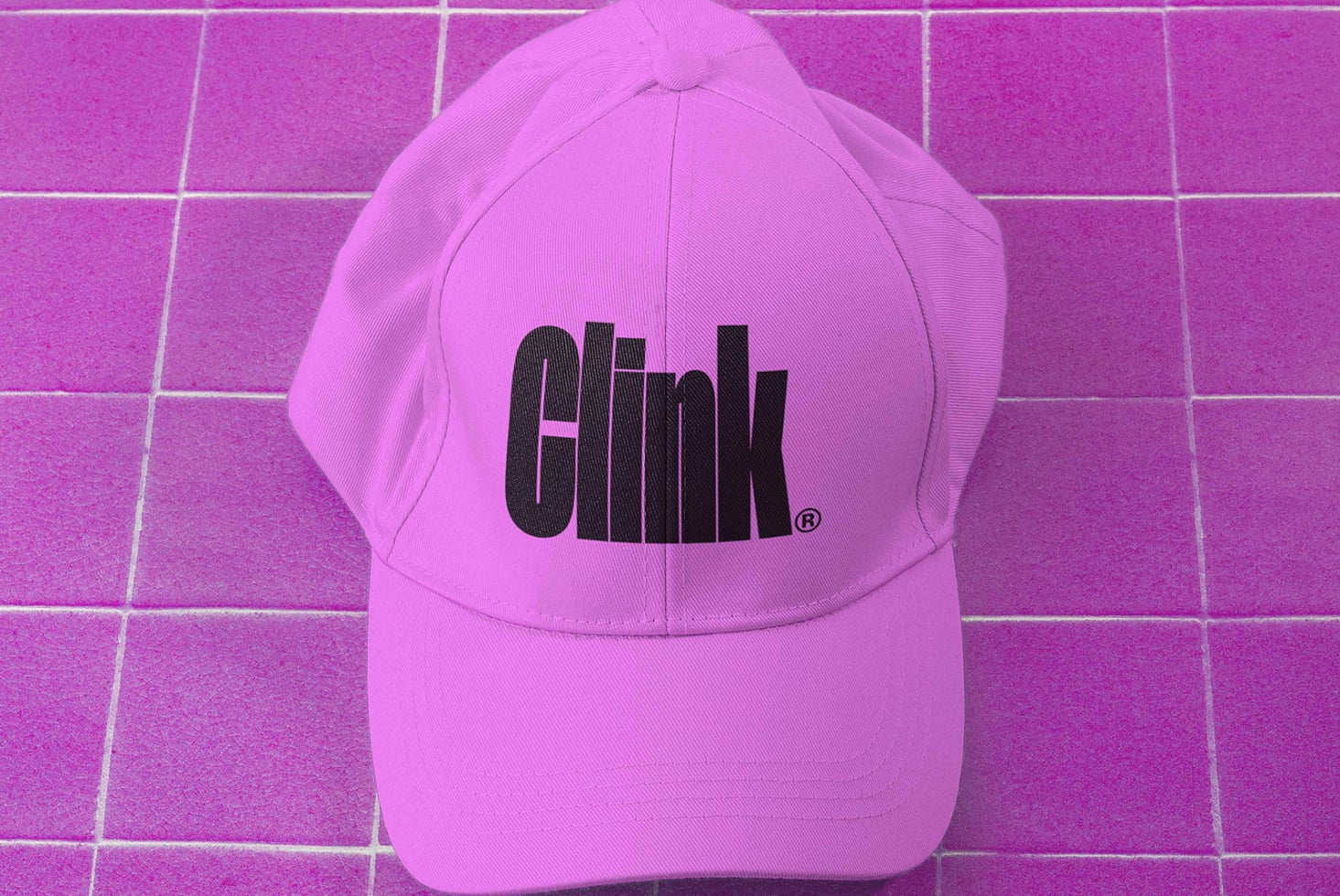 Hot pink baseball cap with black logo on matching magenta tile backdrop