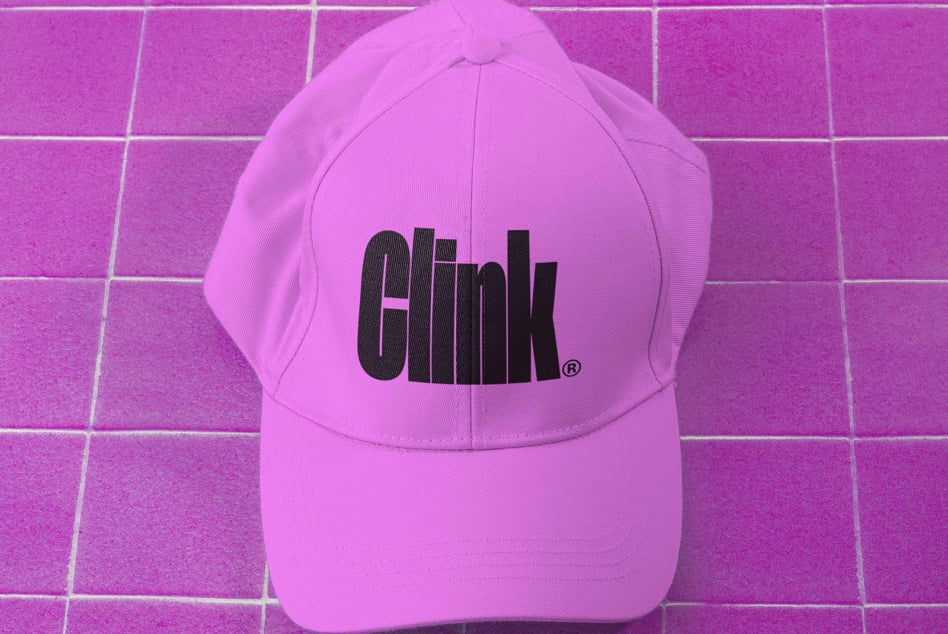 Hot pink baseball cap with black logo on matching magenta tile backdrop
