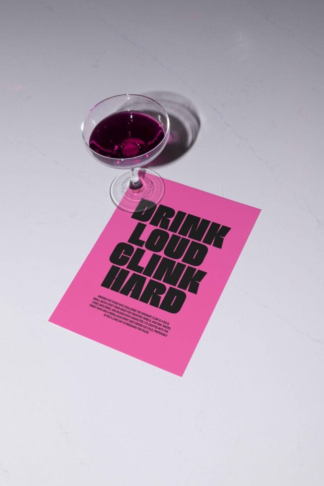 Pink flyer with bold black font saying Drink Loud Clink Hard against a white background alongside a cocktail glass. Keywords: mockups templates fonts graphics.