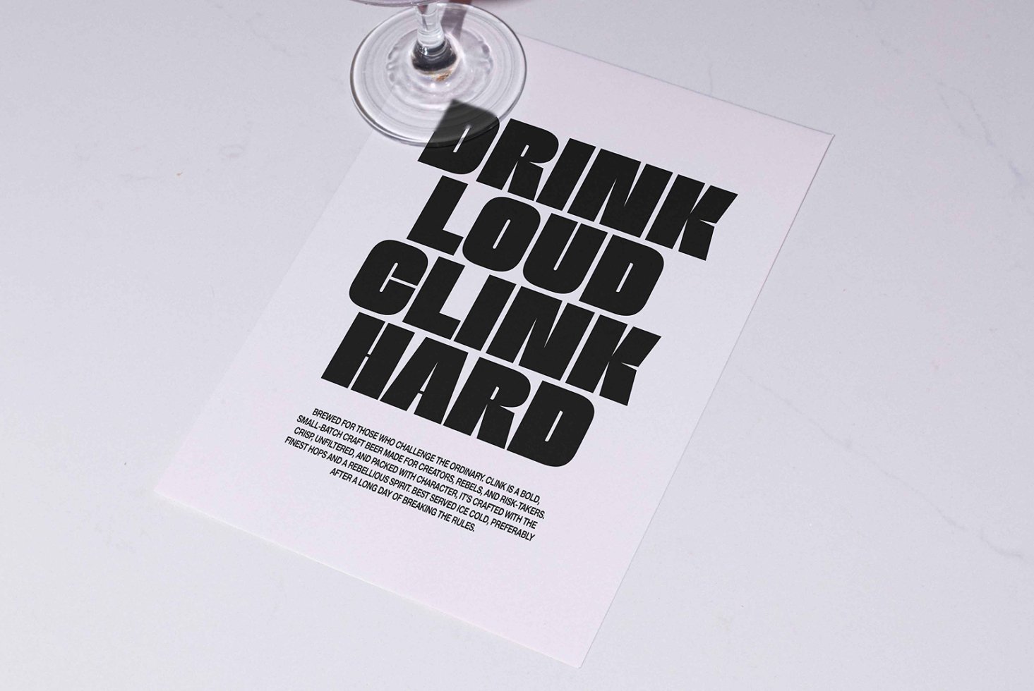 Flyer on marble table with bold black font that reads Drink Loud Clink Hard, ideal for designers seeking typography inspiration and graphic templates.