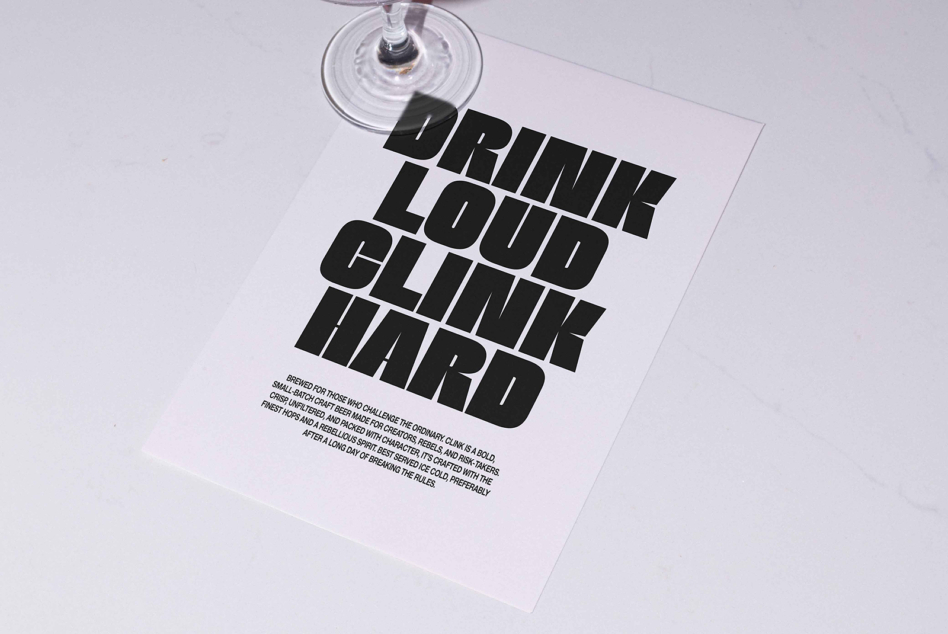 Flyer on marble table with bold black font that reads Drink Loud Clink Hard, ideal for designers seeking typography inspiration and graphic templates.