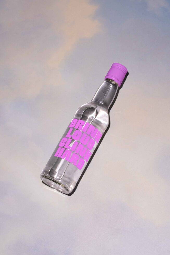 Mockup of a glass bottle with bold stylish typography design on a reflective surface ideal for digital asset designers and branding presentations. Keywords: mockup, typography.