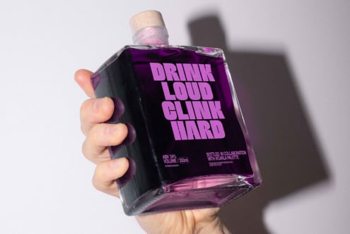 Hand holding a square bottle with purple liquid and bold typography. Perfect for packaging mockups, graphic design inspiration, and branding templates.