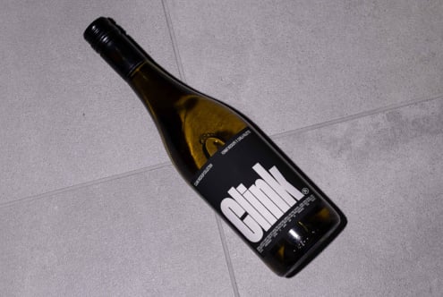 Wine bottle mockup with modern label on grey tile floor. Ideal for designers seeking realistic branding presentations and packaging visuals.