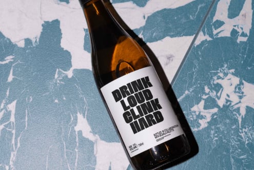 Wine bottle mockup on a blue marbled surface with bold black text label Drink Loud Clink Hard perfect for design presentations branding digital assets