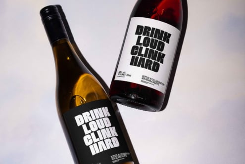 Two wine bottles with bold typography labels reading Drink Loud Clink Hard suitable for graphic design templates and mockups for designers.