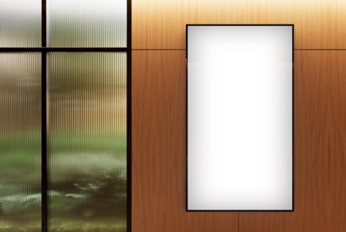 Vertical poster mockup on wooden wall with soft lighting and frosted glass partition. Ideal for interior design presentations or branding visuals.