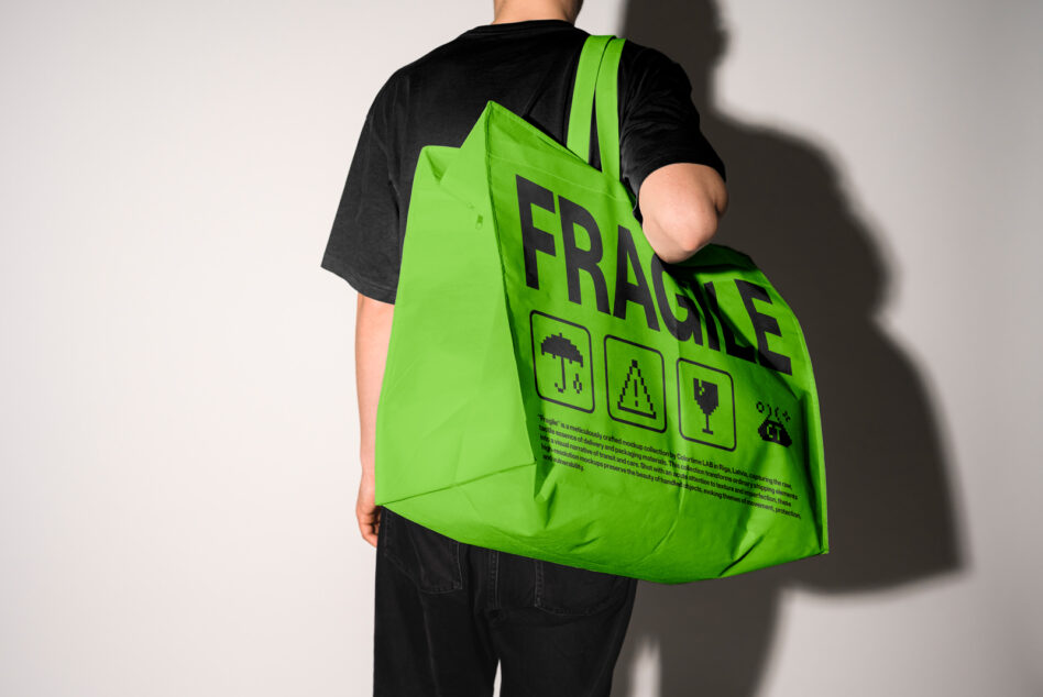Bright green tote bag worn on shoulder, showing FRAGILE design with pixel graphics