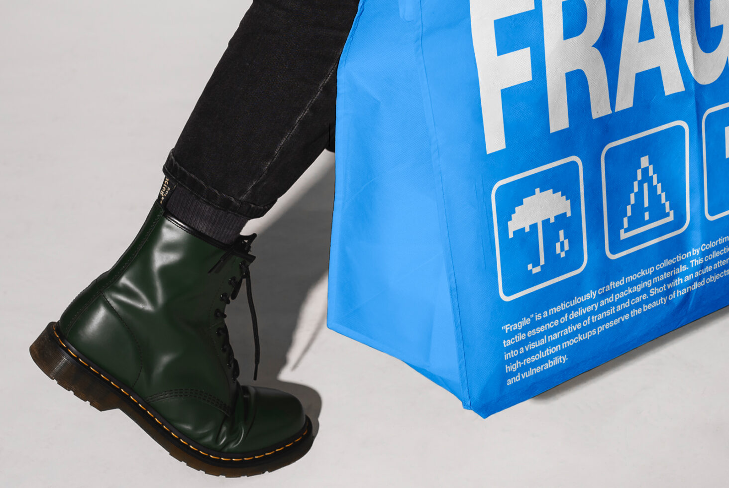 Green boot steps next to blue tote bag with bold typography Fragile. Graphic icons and texture visible. Ideal for mockup, product display, design projects.