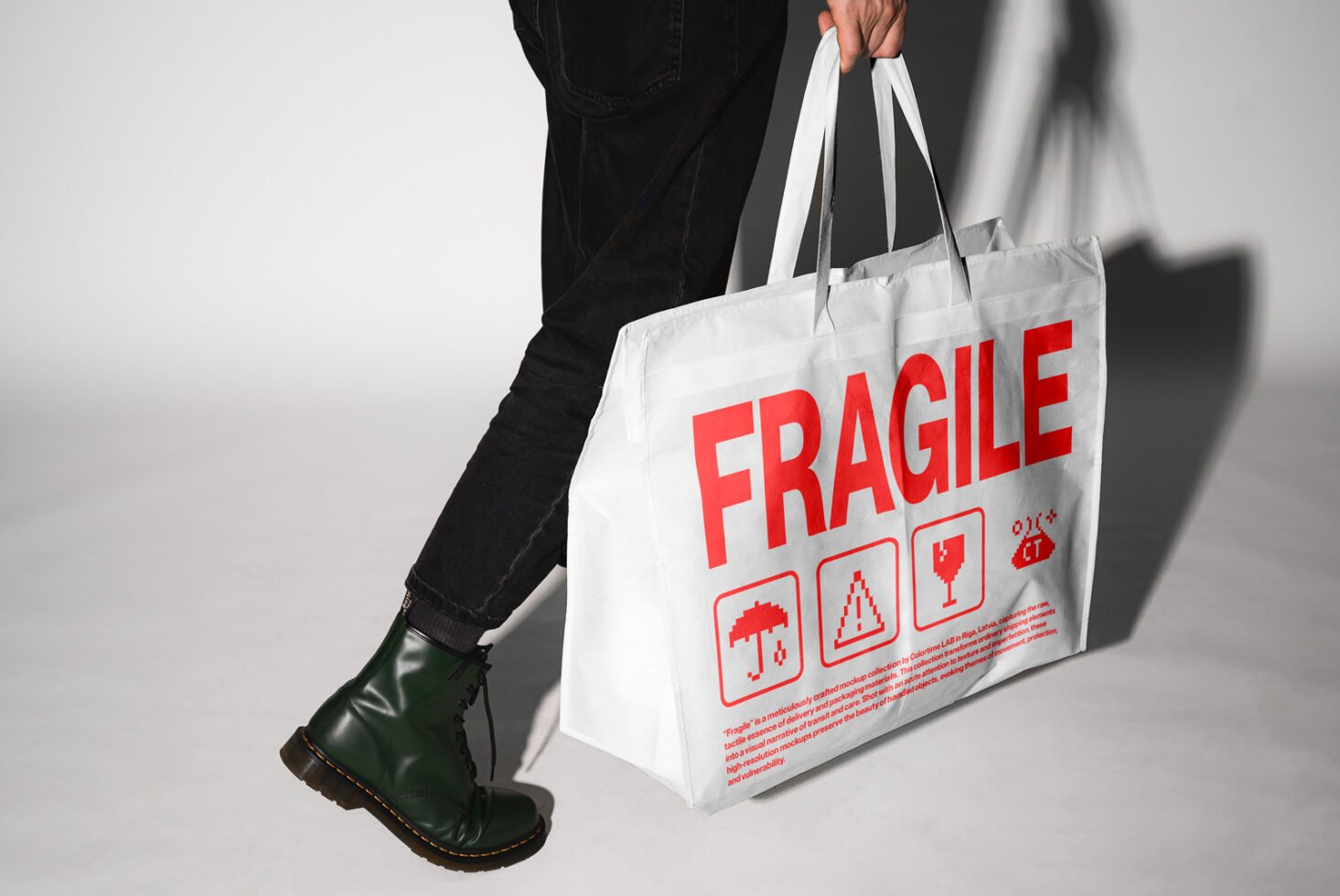 Person carrying white tote bag with red fragile text and icons. Perfect for mockup designs, packaging projects, and branding visuals. Designers asset.